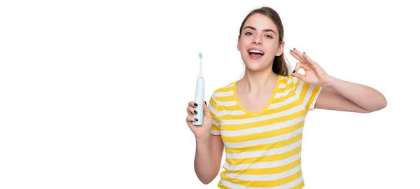 Веселая молодая женщина с электрической зубной щеткой изолированы на белом фоне. ok — стоковое фото