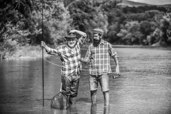 Juntos no amor. dois pescadores felizes com varas de pesca. Fim de semana. homens maduros pescador. pesca de pai e filho. hobby e atividade esportiva. Isca de truta. amizade masculina. ligação familiar — Fotografia de Stock