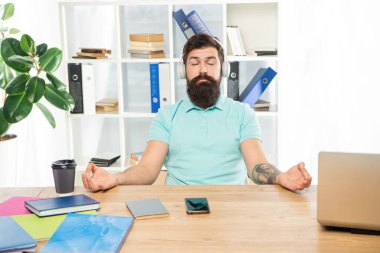 Sakin adam meditasyon yapıyor Mudra 'yı dinlendirici müzik dinliyor ofis masasında kulaklık takıyor, meditasyon yapıyor.
