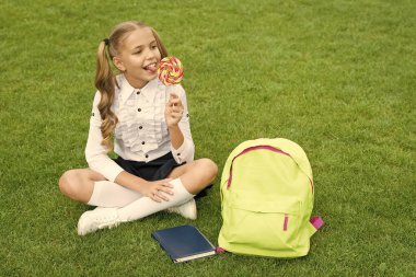 Şeker çocuk. Mutlu okul çocuğu lolipopun tadını çıkar. Tatlıyı. Şeker yemek. Lolipop eğlencesi