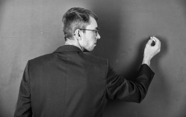 Okula dönüyorum. Üniversite öğretmeni tahtaya yazı yazar. Kolejde öğrenci eğitimi. Modern eğitim konsepti. Genç ama yetenekli bir iş adamı. Tipik bir ofis çalışanı. Adam gözlük ve ceket giyiyor.