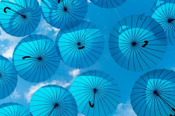 Şemsiye gökyüzü arka planı. Mavi şemsiyeler yukarı sarkmış. Sokak dekorasyonu — Stok fotoğraf