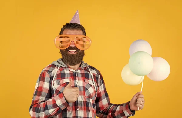 Está com bom aspecto. Feliz aniversário para ti. Celebração de férias masculinas. Um tipo barbudo com balões de festa. homem brutal sem barba com barba comemorar o sucesso do negócio. expressar pura felicidade — Fotografia de Stock