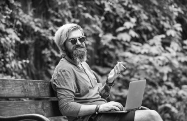 İstediğin yerde çalışabilirsin. Hippi parkta ilham kaynağı oldu. Çevik iş. Sakallı adam park doğasında bankta oturuyor. Çalış ve rahatla. Temiz hava. Gezici internet. İnternetten alışveriş. Çevrimiçi çalışma