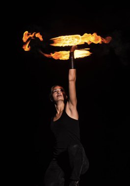 Seksi kız dönen, yanan poi 'yi döndüren, gece karanlığında ateş yörüngesi yaratan, dönen.