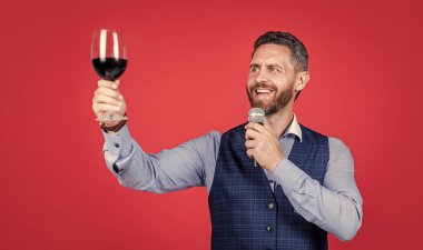 Mutlu adam kadeh kaldırıyor kadehini kırmızı arka plan içmeden önce kadeh kaldırmak için, şerefe