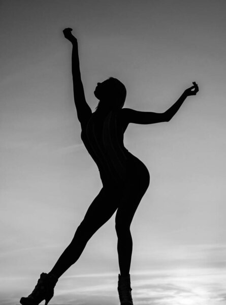 Dance position. shade and shadow. woman silhouette on sky background. sense of freedom. female silhouette on sunset. woman dance in sunrise. dark figure of dancer. dancing in evening.