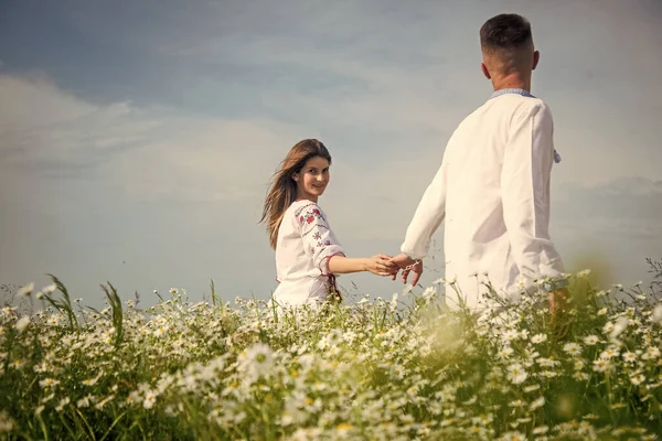 Birbirine aşık çiftler. Papatya tarlasında kadın ve erkek. yaz çiçeği çayırı. — Stok fotoğraf