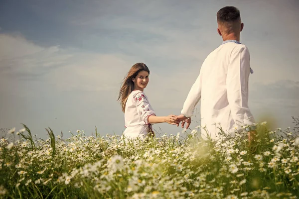 couple in love. man and woman in camomile field. summer flower meadow.