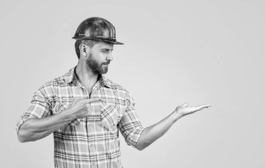 Her şey mükemmel olmalı. Adam mimar ürünü sunuyor. Adam işçi üniforması giyiyor. Miğferli müteahhit. Olgun adam kareli gömlek giyer. Profesyonel inşaatçı ya da tamirci. İnşaat mühendisi