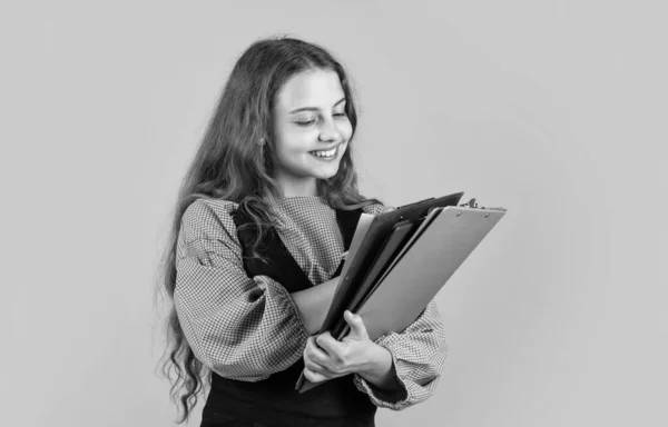 Šťastně vypadající dívka s dokumentem složky, soustředěný na práci — Stock fotografie