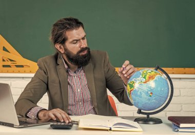 Konuyu öğrenmek. Sakallı konsantre adam coğrafya dünyasına bak. Haritayı inceliyorum. gayri resmi eğitim. Erkek öğrenci ders sırasında sınıfta oturur. Sınavı geç. Kimse seni durduramaz.