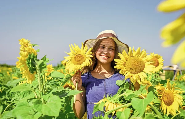 Χαριτωμένο κορίτσι σε ψάθινο καπέλο με τα πόδια ηλιοτρόπια αγρόκτημα, υγιή ζωή — Φωτογραφία Αρχείου