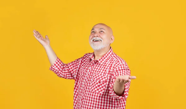 Gelukkig volwassen man in geruite shirt op gele achtergrond — Stockfoto