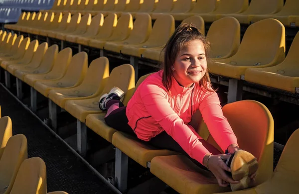 Atlétikai illeszkedés rugalmas lány gyermek nem splits láb nyújtás torna edzés stadion ülések, tornász — Stock Fotó