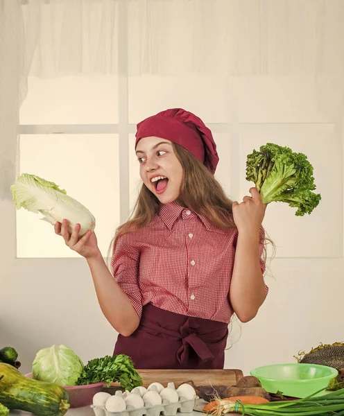 Glückliches Teenager-Mädchen beim Zubereiten der Mahlzeit. Kinder tragen Kochuniform. Kind mit Hut und Schürze. — Stockfoto