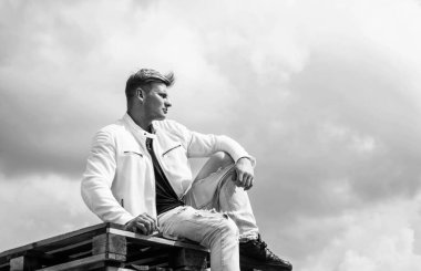 Beyaz şehir kıyafetleri içinde kendine güveni olan genç bir adam açık havada, moda.