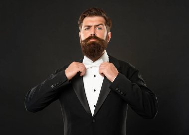 Smokinli sakallı damat siyah arka planda, papyonlu.