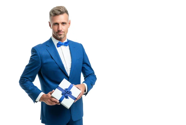 Mann in blauer Fliege Anzug halten Geschenk-Box isoliert auf weiß mit Kopierraum — Stockfoto
