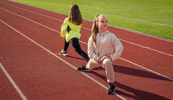 Treinamento físico para crianças. Raparigas aptas a fazer lunging para fora. Educação em treinamento físico. Aula de esportes — Fotografia de Stock