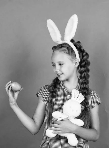 Feliz adolescente chica en conejito orejas celebrar conejo juguete y huevo, feliz Pascua —  Fotos de Stock