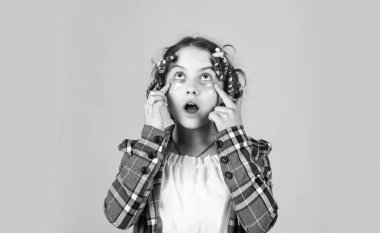 Güzel bir saç stili yap. Mutlu çocuk. Kuaför salonu. Mükemmel güzellik. Sarı arka planda saç tokası ve saç tokası olan bir kız. Saçlarının etrafında kıvırcık kızlar. Harika bir saç stili.