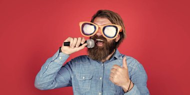 Harika bir ses. Parti gözlüklü vahşi beyaz hippi. Karaoke şarkıcısı. Tıraşsız, uzun saçlı adam. Berber ve kuaför. Erkek mikrofonda şarkı söyler. Mikrofonlu komik sakallı adam.