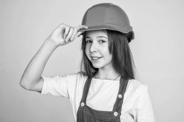 Adolescente trabalhador menina em capacete protetor e uniforme no fundo cinza, bem-vindo — Fotografia de Stock