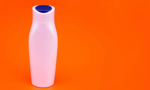 Botella de champú blanco sobre fondo naranja, higiene — Foto de Stock