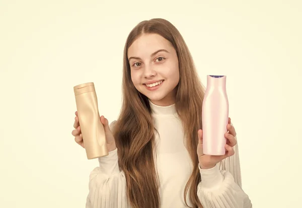 Feliz adolescente chica presentando champú o pelo cuerpo acondicionador botella aislado en blanco, queratina —  Fotos de Stock