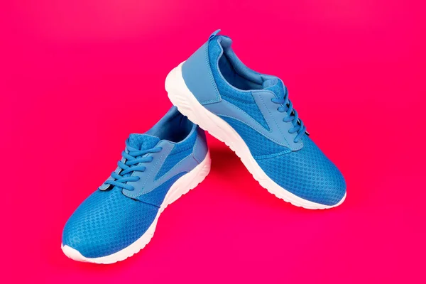 Pair of comfortable blue sport shoes on pink background, new pair — Stock Photo, Image