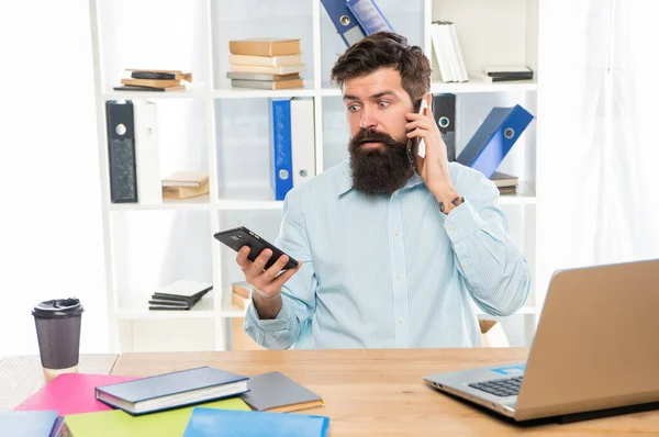 Järkyttynyt liikemies puhuu matkapuhelimella älypuhelimella toimistossa, liikkuvuus — kuvapankkivalokuva