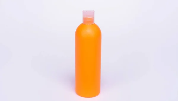 Bouteille de shampooing orange isolée sur fond blanc, soin de la peau — Photo