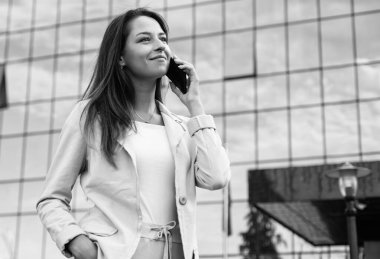 Kız dışarıda telefonla konuşuyor. Şık giyinmiş güzel bir bayan. Kadın güzelliği ve moda. Akıllı telefonlu CEO iş kadını. İş iletişimi. Zarif takım elbiseli kendine güvenen bir kadın. Mutlu ol.