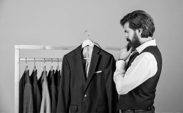 Επίτευξη επιτυχίας ως σχεδιαστής. Όμορφος γενειοφόρος με κλασική στολή. Άνδρας με προσαρμοσμένο κουστούμι που παρουσιάζει ακριβό σμόκιν. Ανδρικά ρούχα σε μπουτίκ. Άνδρας με κοστούμι — Φωτογραφία Αρχείου