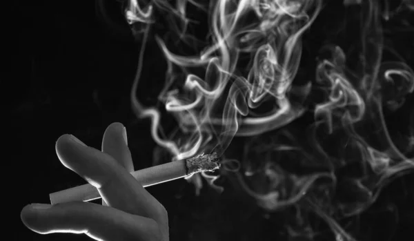 Rök och kvävs. Cigarettrök mörk bakgrund. Ångande cigarett i manlig hand — Stockfoto