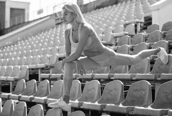 Stadyum antrenmanında spor giyim bölümünde bayan sporcu, esneme hareketleri. — Stok fotoğraf