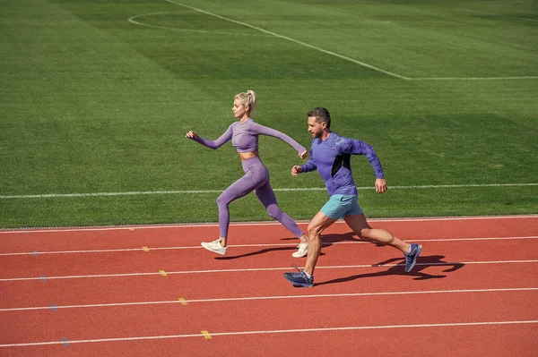 Enerji dayanıklılığı. Zıplayan sporcu tipler. Erkek ve kadın spor eğitmeni koşar. Fitness çifti eğitimi