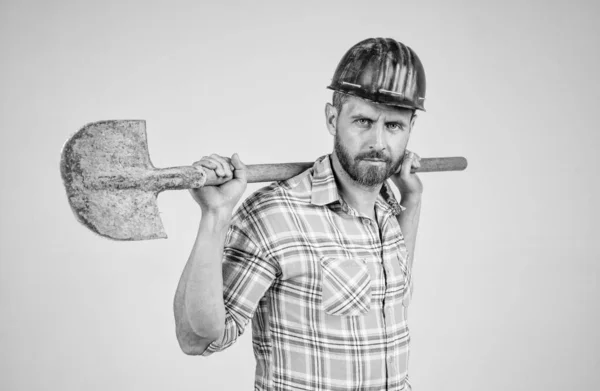 Knappe man expert in de bouw veiligheidshelm en geruit shirt op de bouwplaats met schop, beroep — Stockfoto