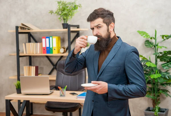 Guapo maduro empresario en chaqueta teniendo café descanso en la oficina, negocio — Foto de Stock