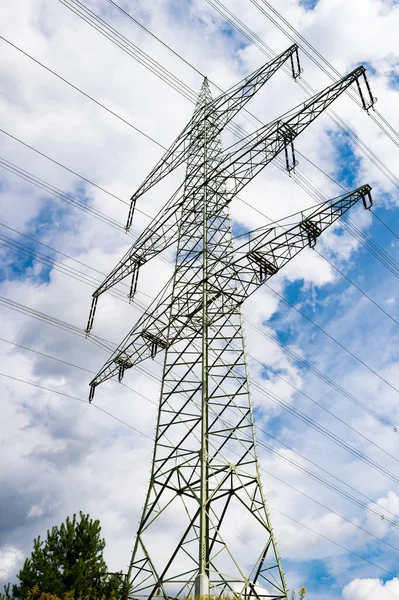 Torre de transmissão aérea rede elétrica estrutura metálica de baixo para cima no céu nublado — Fotografia de Stock