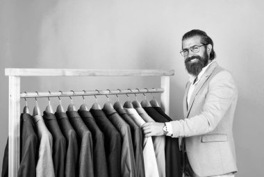 Saçları taranmış gerçek bir beyefendi. Erkek güzellik ve moda. Gösteri salonu konsepti. Resmi giysili sakallı adam. Zarif iş adamı resmi etkinlik için kıyafet seçiyor. Daha atölye ya da gardırop. İlahiyi hisset