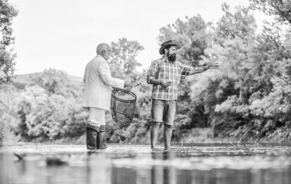 Acil servise yardım eden refakatçisi olan balıklar. Sakallı adam, zarif iş adamı balığı birlikte. Balık tutmayı öğren. Uzman balıkçı. Erkek arkadaşlar nehir altyapısını rahatlatıyor. Kişisel eğitmen. Balık tutma becerileri — Stok fotoğraf