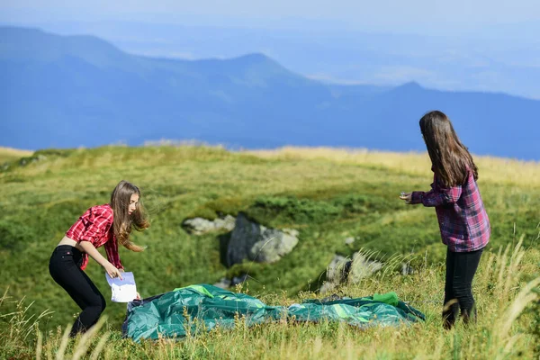 Kempingezési képességek. A semmi közepén. A lányok felállítottak egy sátrat a hegy tetején. Kempingezés és túrázás. Nyári kalandok. Ideiglenes szállás. Kempingezés. Hasznos, ha van partnere a sátor felemelésében. — Stock Fotó