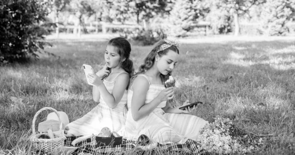 I bambini piccoli guardano i telefoni cellulari che soffrono di dipendenza da smartphone al picnic estivo in famiglia, nomofobia — Foto Stock