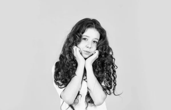 Beautiful little model. Healthy curls. Long hair. Easy hairdo. Beauty supplies. Perfectly untangle curly hair. Pretty girl curly hair yellow background. Hairdresser salon. Adorable small child — Stock Photo, Image