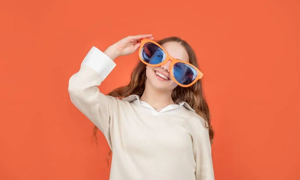 Glückliches Kind lächelt in großen lustigen Brille braunen Hintergrund — Stockfoto