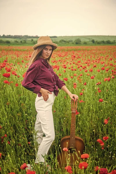 Campagne printanière. dame porter chemise à carreaux et chapeau dans le champ de fleurs. chanteur de country. — Photo
