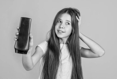 Sevimli kız çocuğunun saç stili çok güzel. Şişede losyon kullan. Güzellik ürünü.