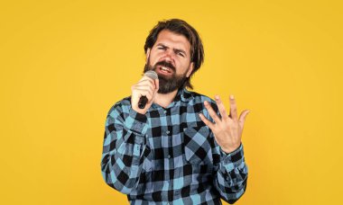 Duygusal sakallı erkek hippi karaoke 'de mikrofonla şarkı söylüyor, müzik sever.